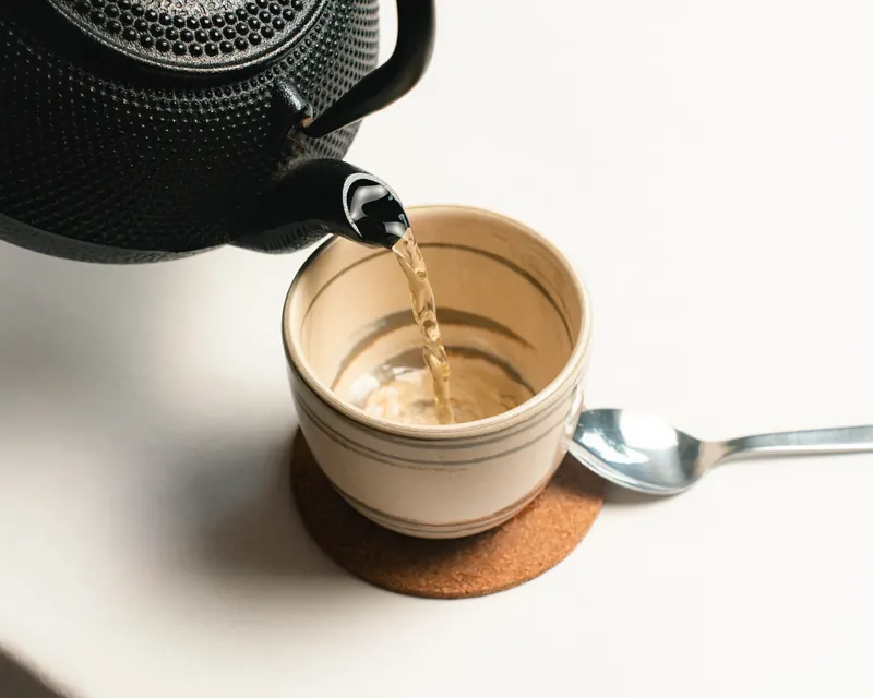 Tea being poured into a ceramic cup